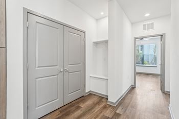 A white hallway with a wooden floor and two white doors. at The Junction at Rockledge Apartments, Rockledge, FL, 32955